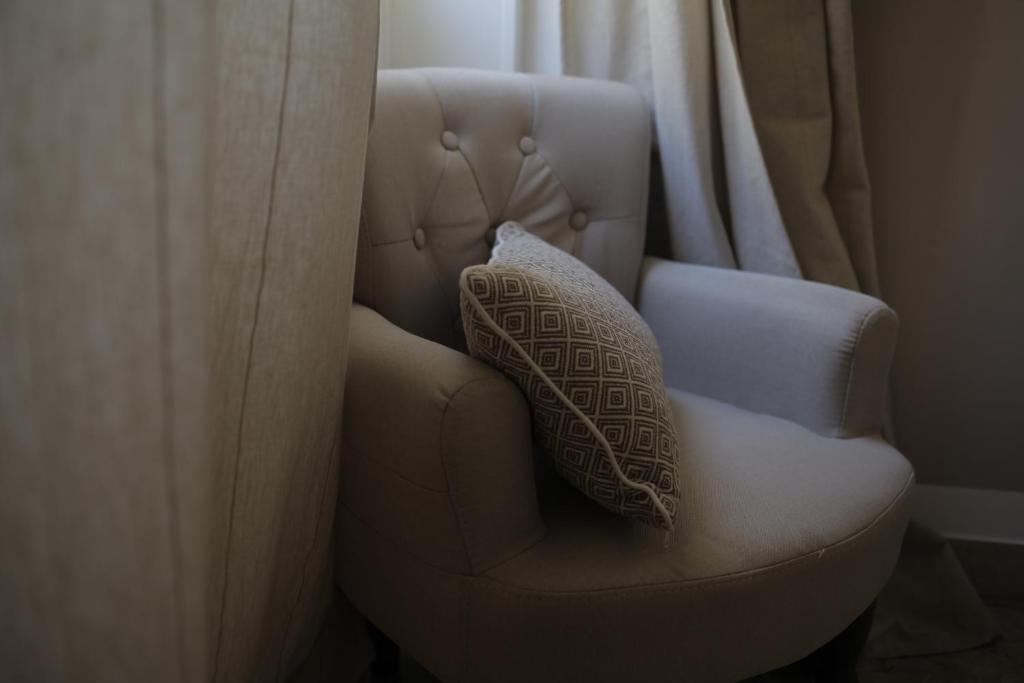 a pillow sitting on a chair next to a window at Dimi House in Lecce