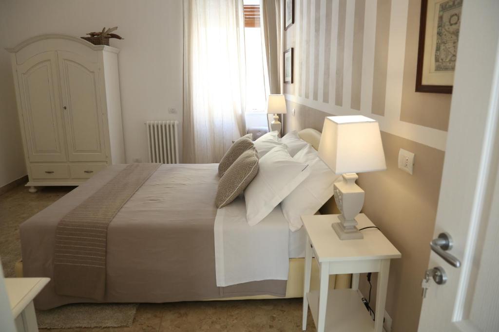 a bedroom with a bed with pillows and a lamp at Dimi House in Lecce