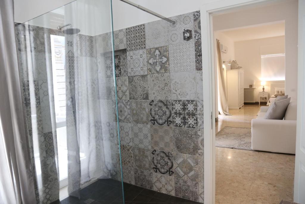 a glass shower in a room with a living room at Dimi House in Lecce