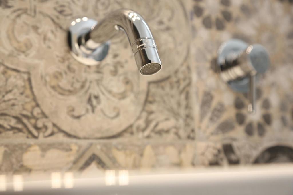 a sink with two faucets in a bathroom at Dimi House in Lecce