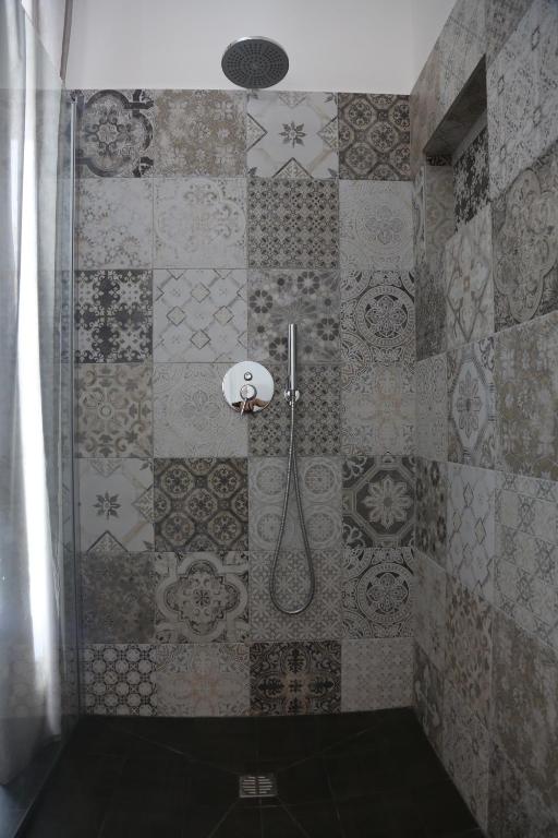 a bathroom with a shower with a tiled wall at Dimi House in Lecce