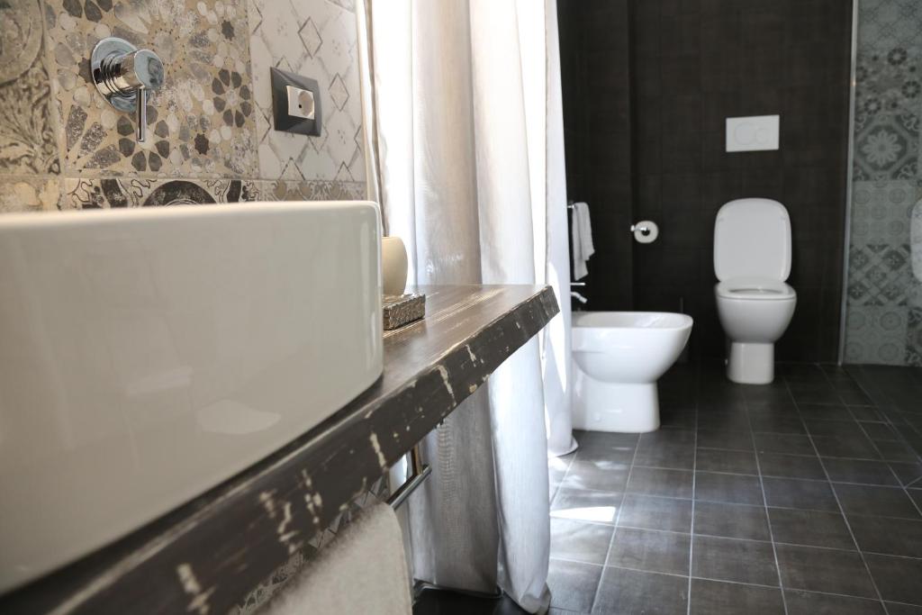 a bathroom with a white toilet and a sink at Dimi House in Lecce