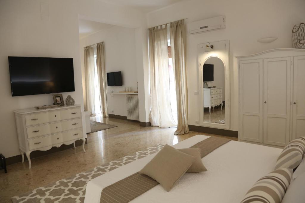 a white living room with a television and a dresser at Dimi House in Lecce