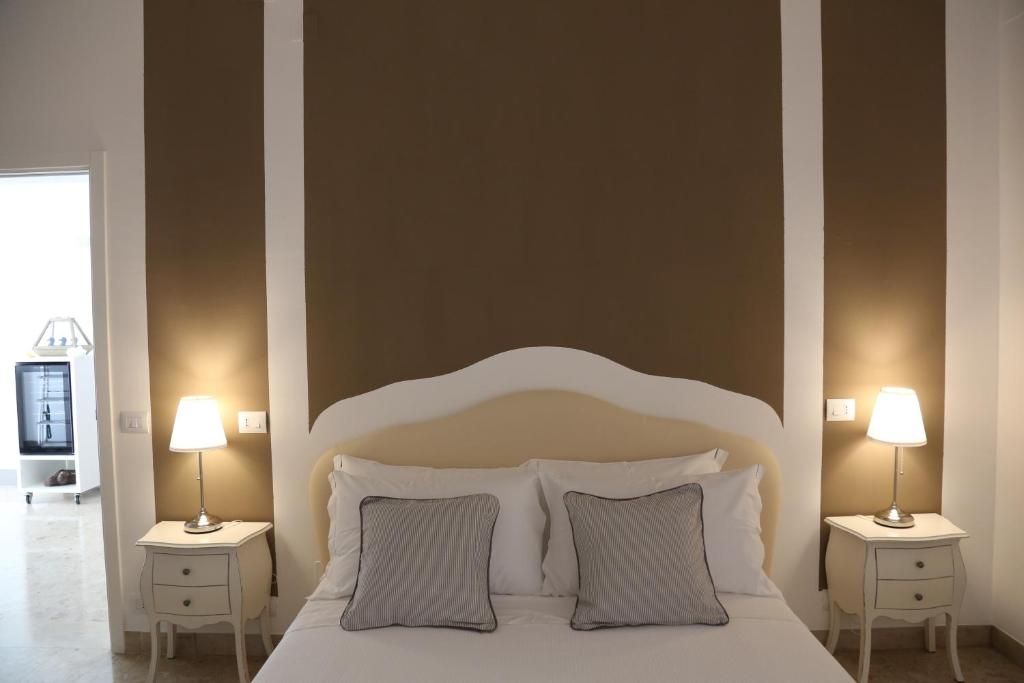 a bedroom with a large white bed with two night stands at Dimi House in Lecce