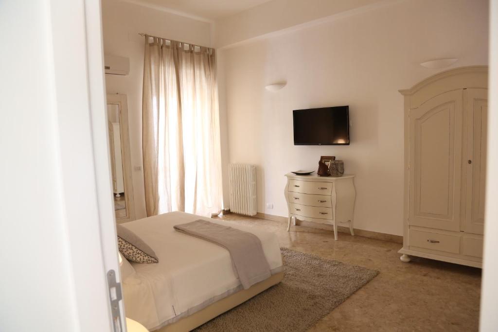 a bedroom with a bed and a dresser with a television at Dimi House in Lecce