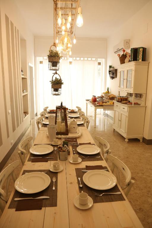 a long table in a kitchen with plates and dishes on it at Dimi House in Lecce