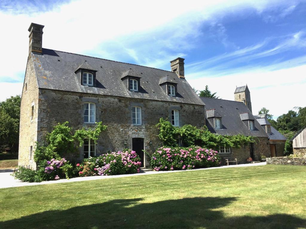 an old stone house with flowers on a lawn at Le Domaine de Belleville in Dragey