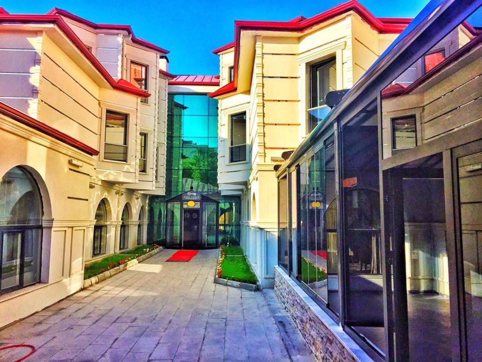 an empty alley between two buildings with glass windows at Kars-i Si̇ri̇n Otel in Kars
