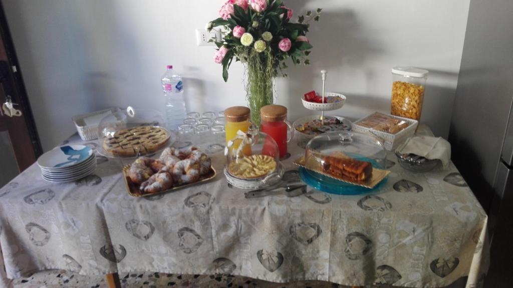 un tavolo ricoperto di cibo e un vaso di fiori di Citrus Garden ad Avetrana