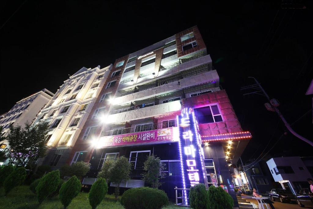 a tall building with lights on it at night at Drama Motel in Boryeong