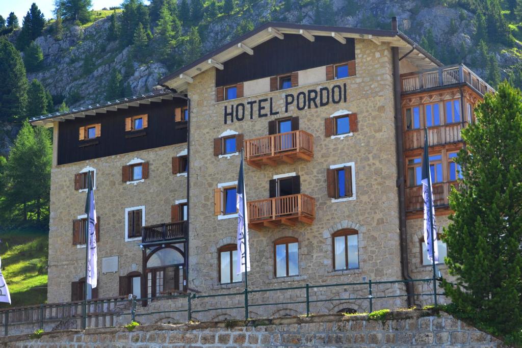 a building with a sign on the side of it at Hotel Pordoi Passo Pordoi in Canazei