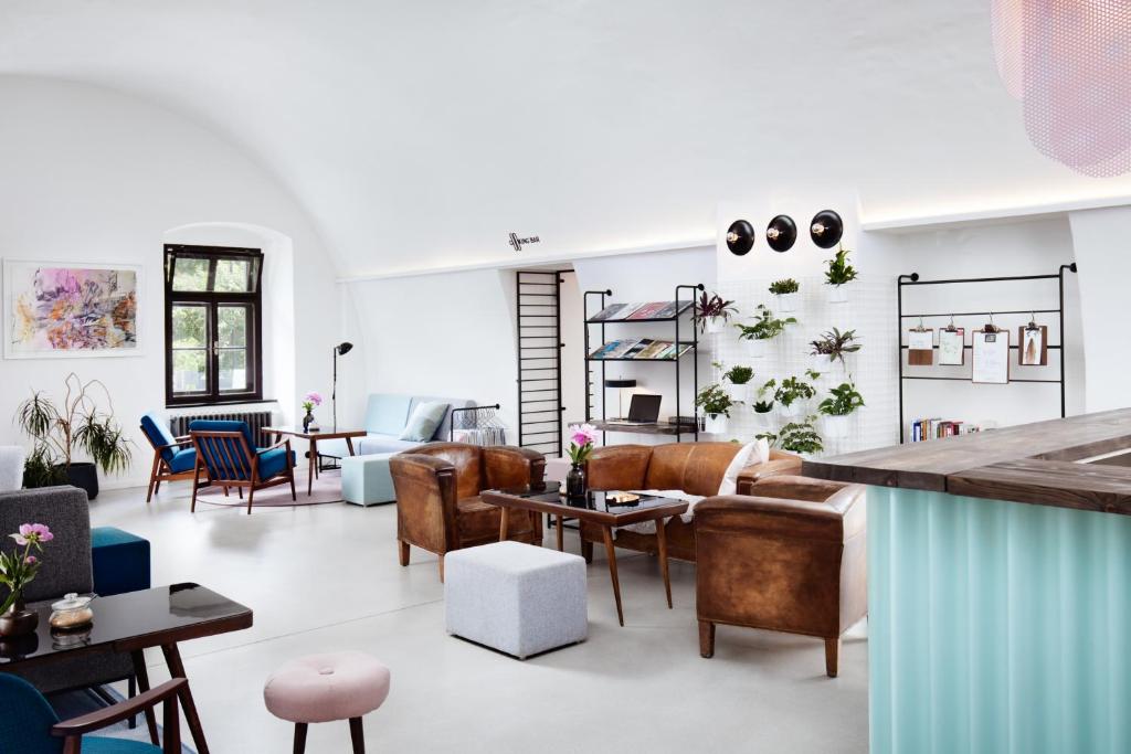 una sala de estar con muchas sillas y mesas en Long Story Short Hostel & Café, en Olomouc