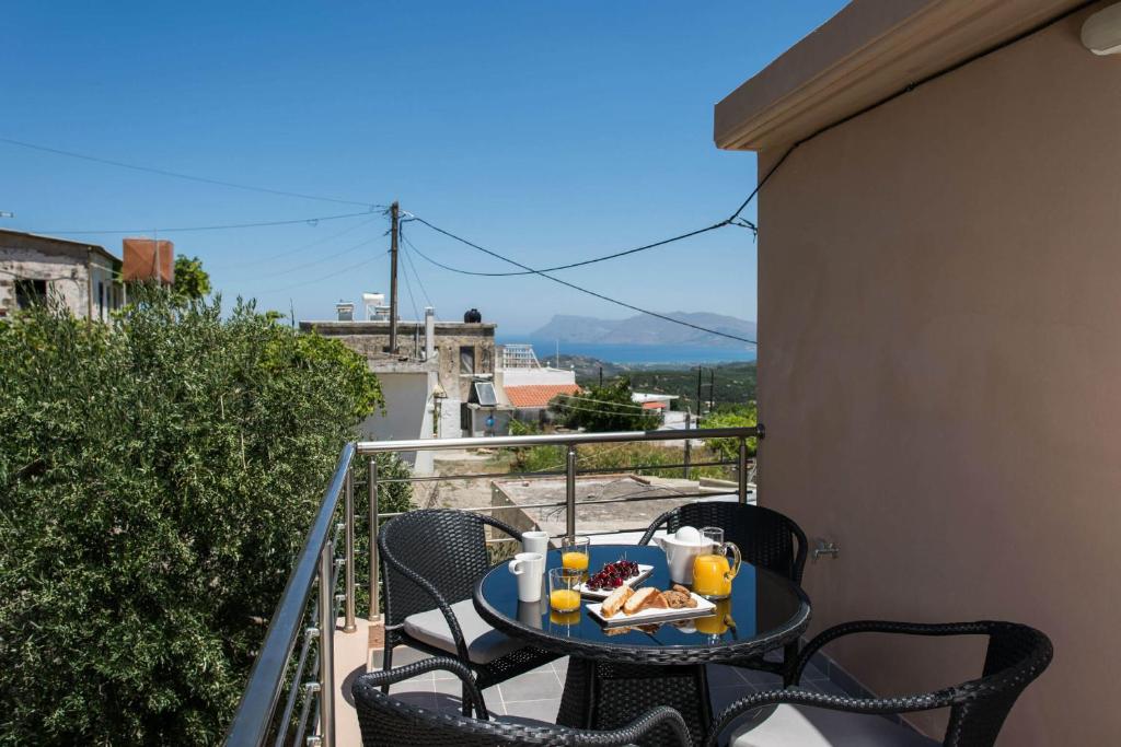 Un balcón con una mesa con comida. en Margiani House en Kaláthenai