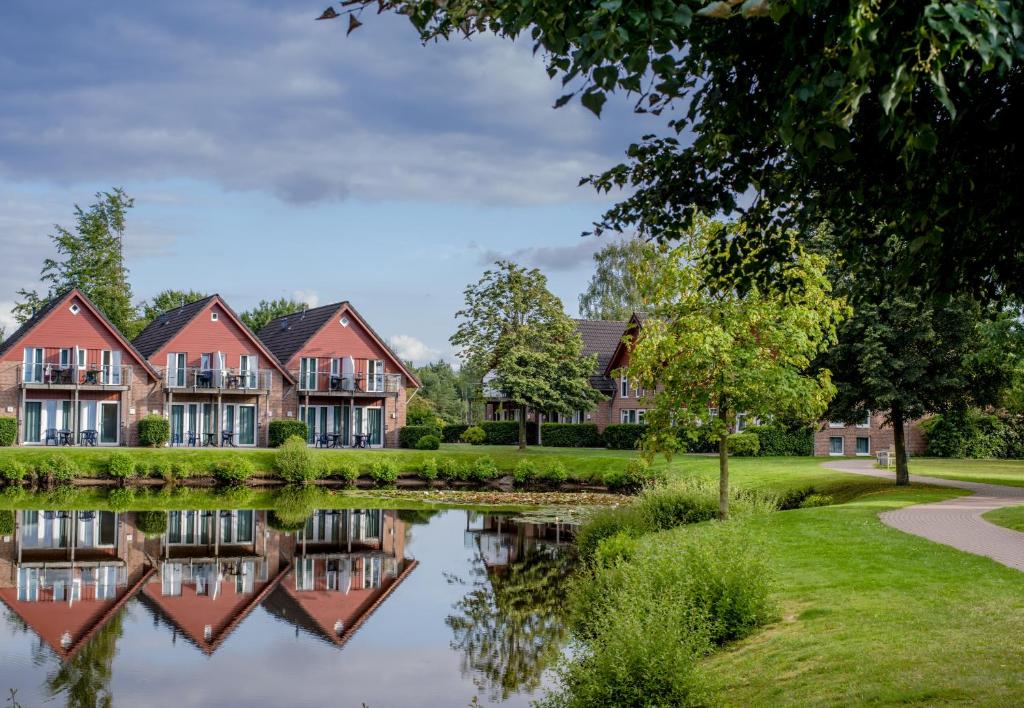a house with a pond in front of it at Eurostrand Resort Lüneburger Heide in Fintel