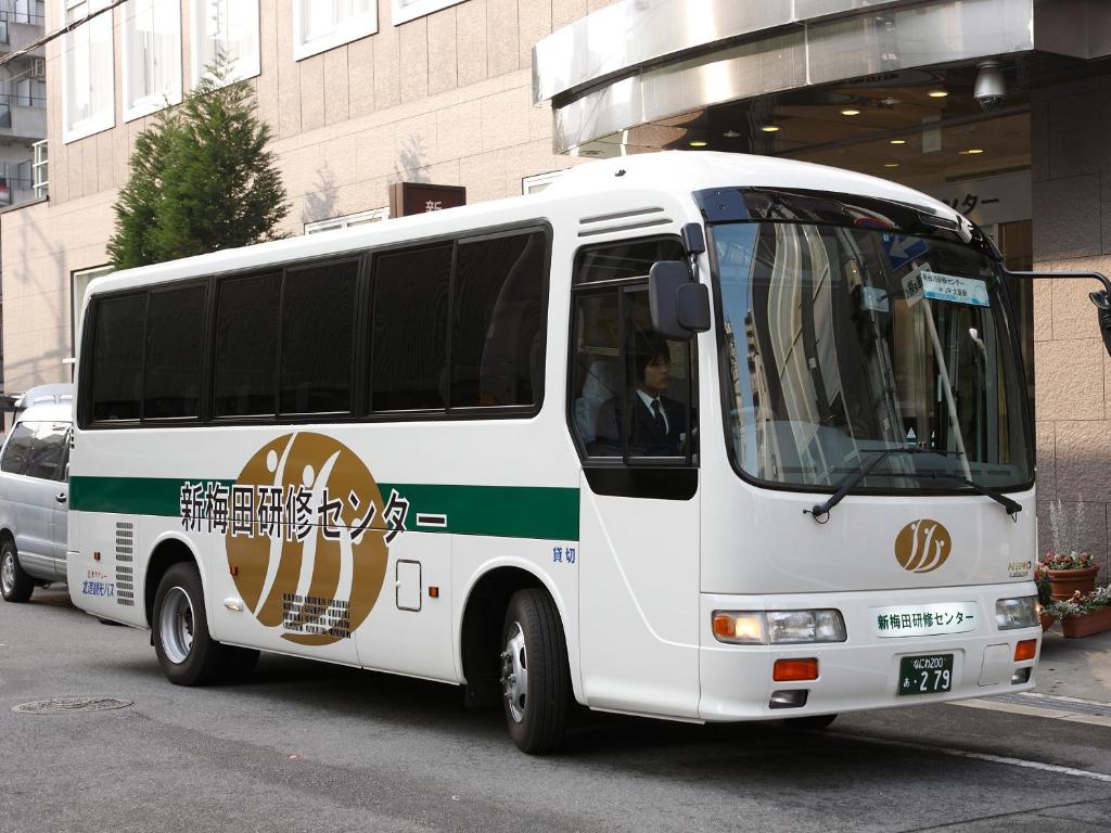 a white bus parked in a parking lot at S.Training Center Hotel Osaka in Osaka