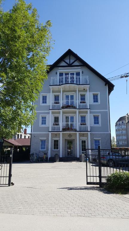 un gran edificio blanco con balcón en la parte delantera en AmberSeason Hotel en Zelenogradsk