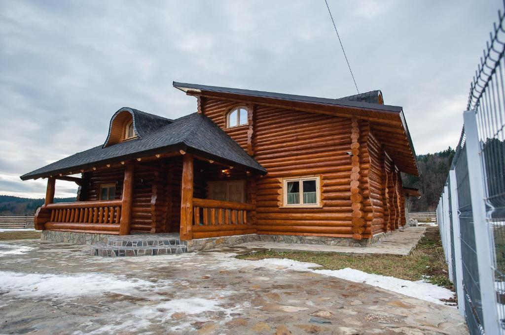 a log cabin with a black roof at Cabana Goralilor in Mănăstirea Humorului