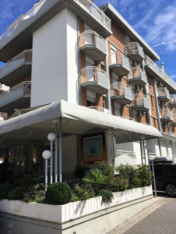 un gran edificio de apartamentos con un toldo delante de él en Residence Moresco, en Lido di Jesolo