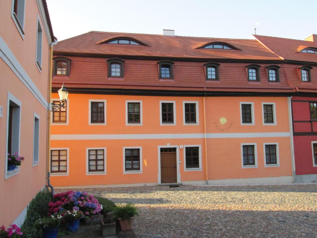 un edificio arancione con tetto rosso di Rittergut zu Groitzsch a Jesewitz