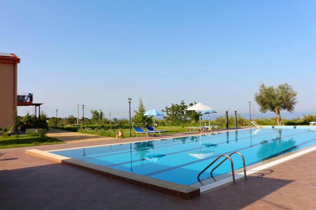 a large swimming pool with blue water in a resort at Case Mistretta in Altavilla Milicia