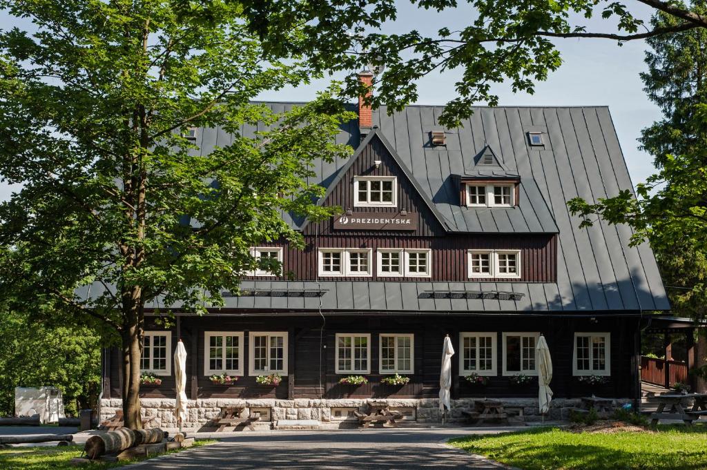 uma grande casa de madeira com um telhado de gambrel em Prezidentská em Bedřichov