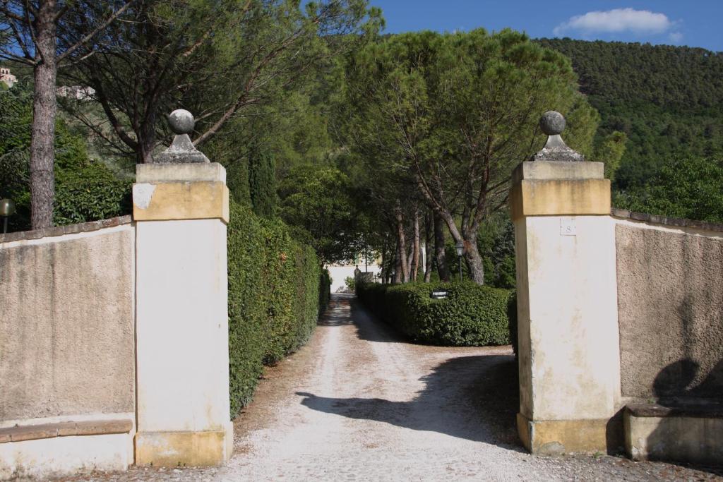 a pair of gates to a garden with trees at Villa del Cardinale in Spoleto