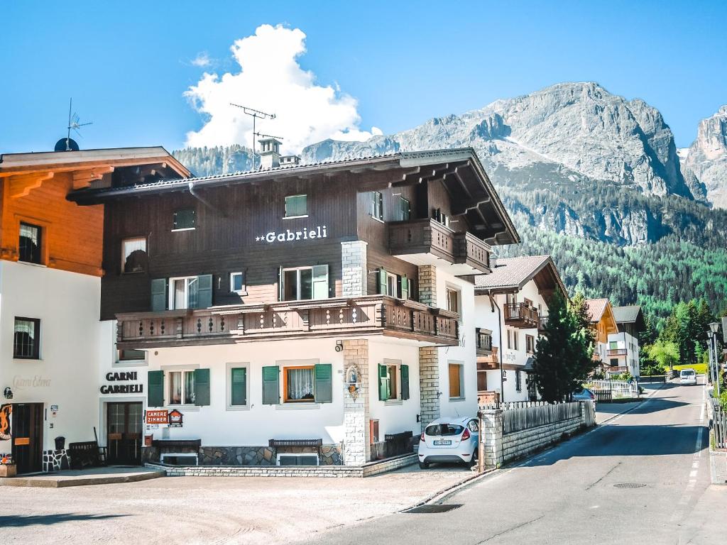 a large building with a view of a mountain range at Garni Gabrieli in Corvara in Badia