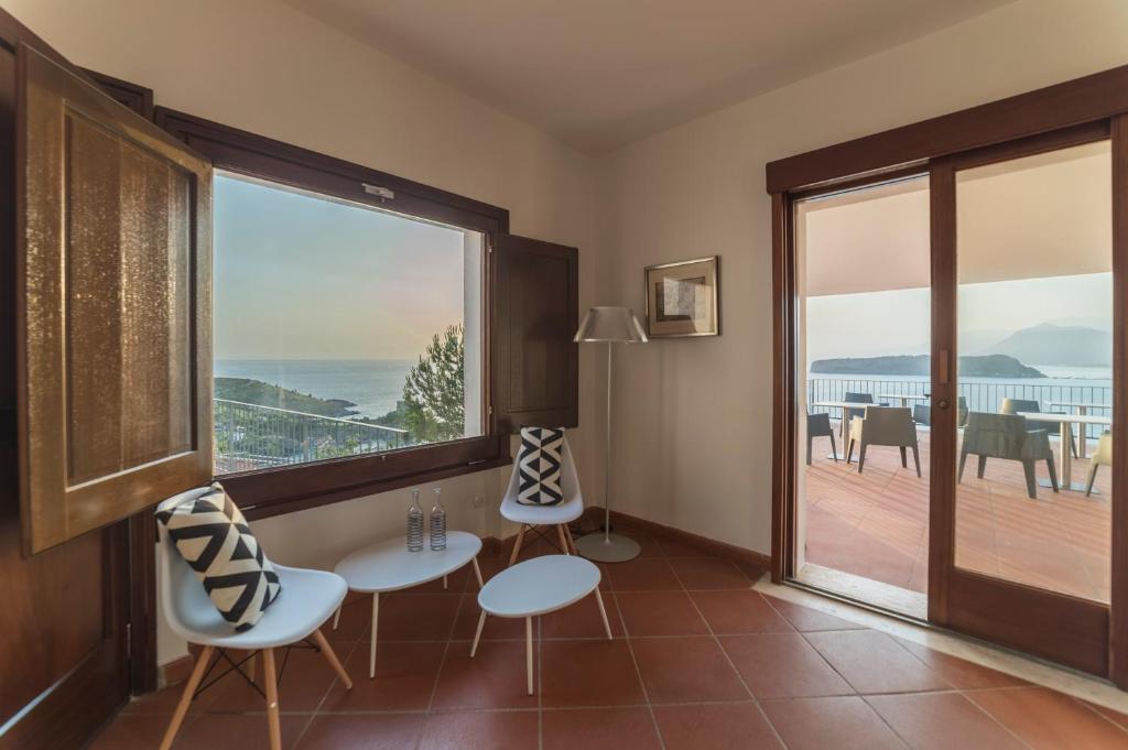 a room with a large window and a table and chairs at Villa Crawford in San Nicola Arcella