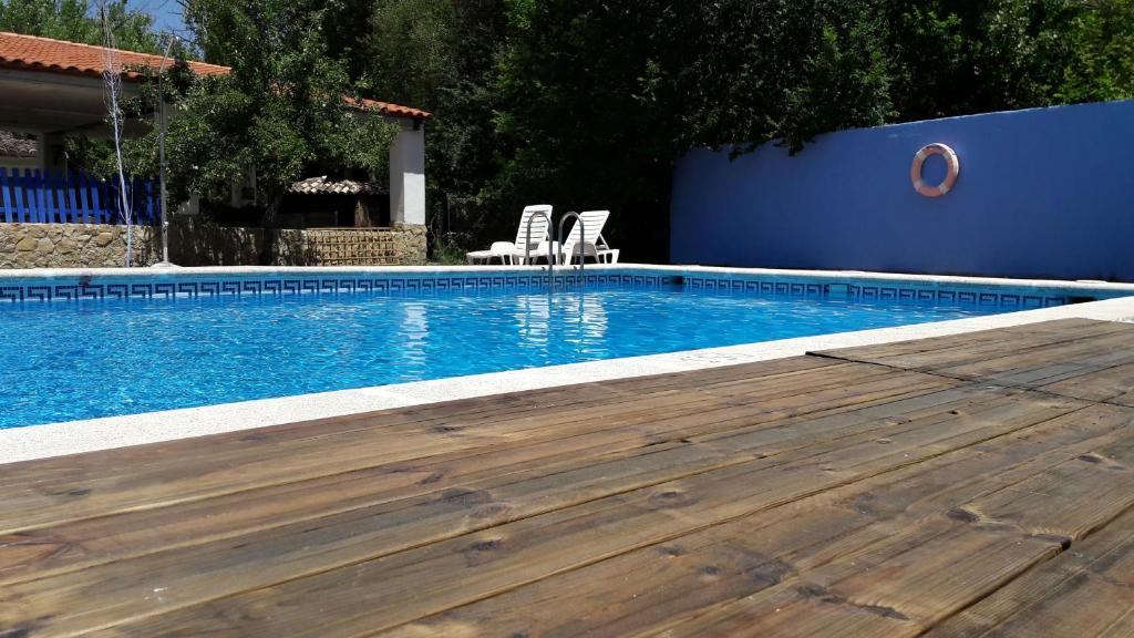 una piscina con 2 sillas y una pared azul en Chorros del Río Mundo, en Riópar
