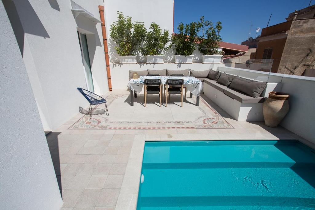 a patio with a table and a couch and a pool at Settegrana in Cinisi