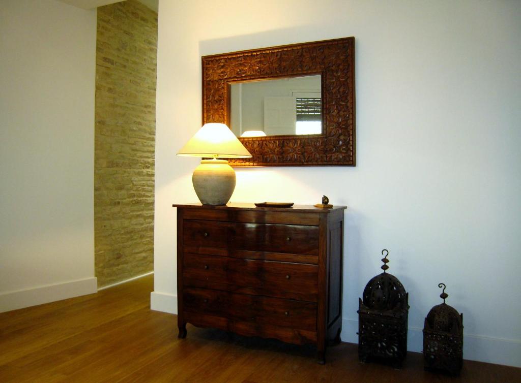 a lamp on a dresser in a room with a mirror at bt6sevilla in Seville