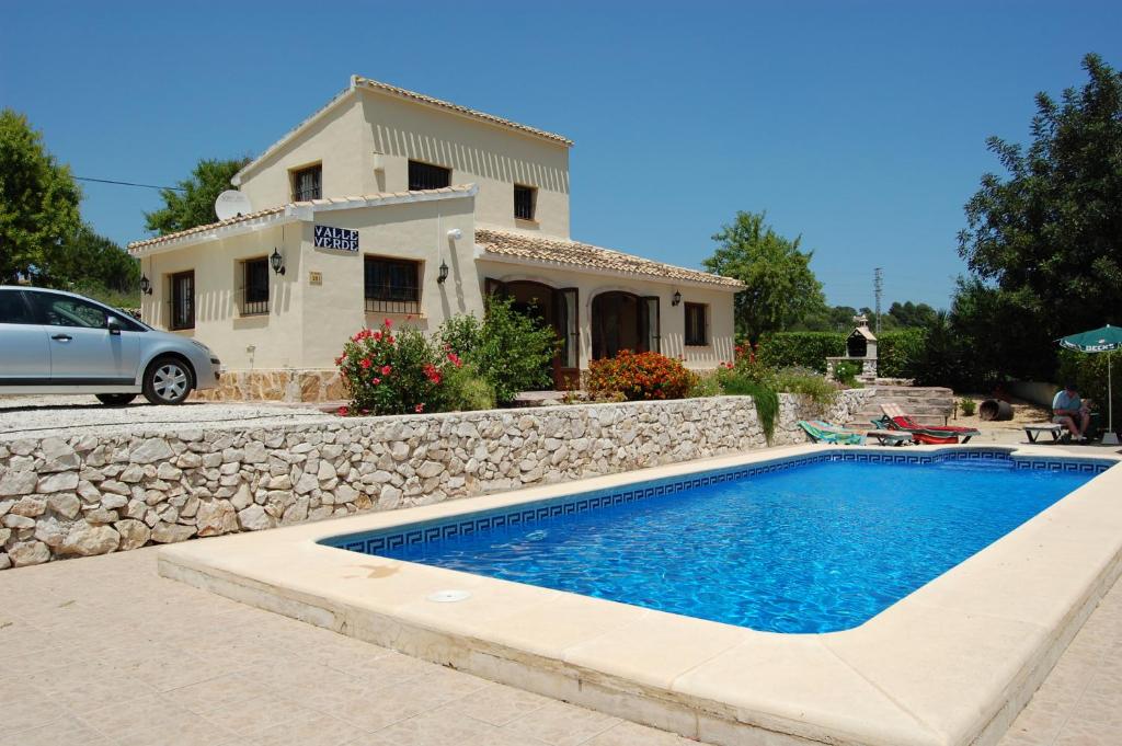 una villa con piscina di fronte a una casa di Valle Verde a Benitachell