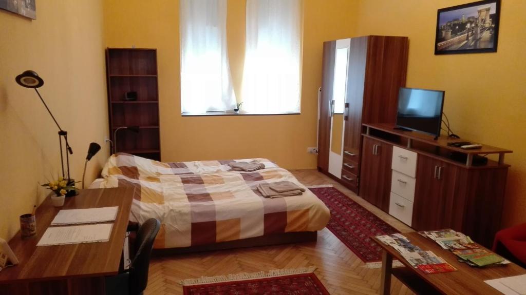 a bedroom with a bed and a desk and a television at Cute apartment close to the center in Budapest