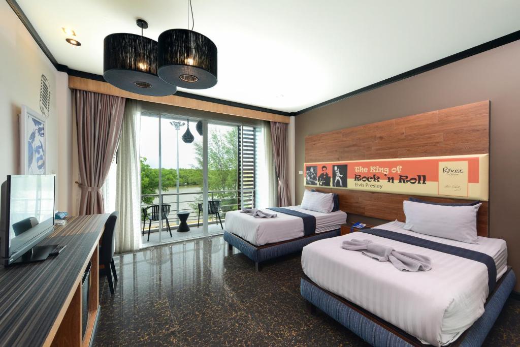 a hotel room with two beds and a television at The River Scene in Krabi
