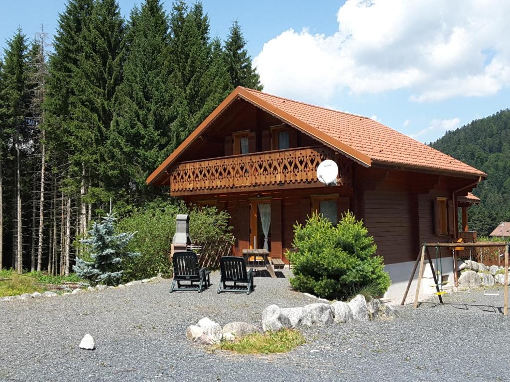 a house with two chairs in front of it at Chalet Mauselaine in Xonrupt-Longemer