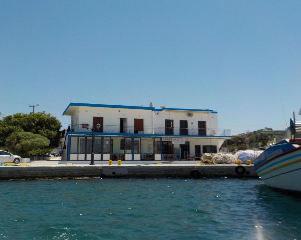 a building on a dock next to the water at Marina's Rooms in Lipsoi