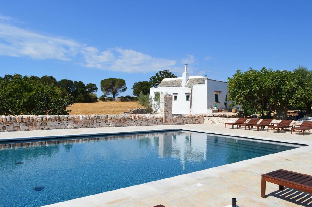 einen Pool vor einem weißen Haus in der Unterkunft Masseria Faraone in Martina Franca