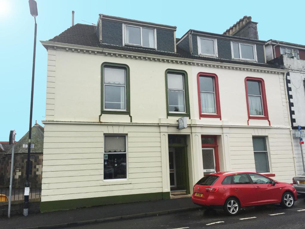 a red car parked in front of a white house at The Ivy House Ferry Link in Stranraer