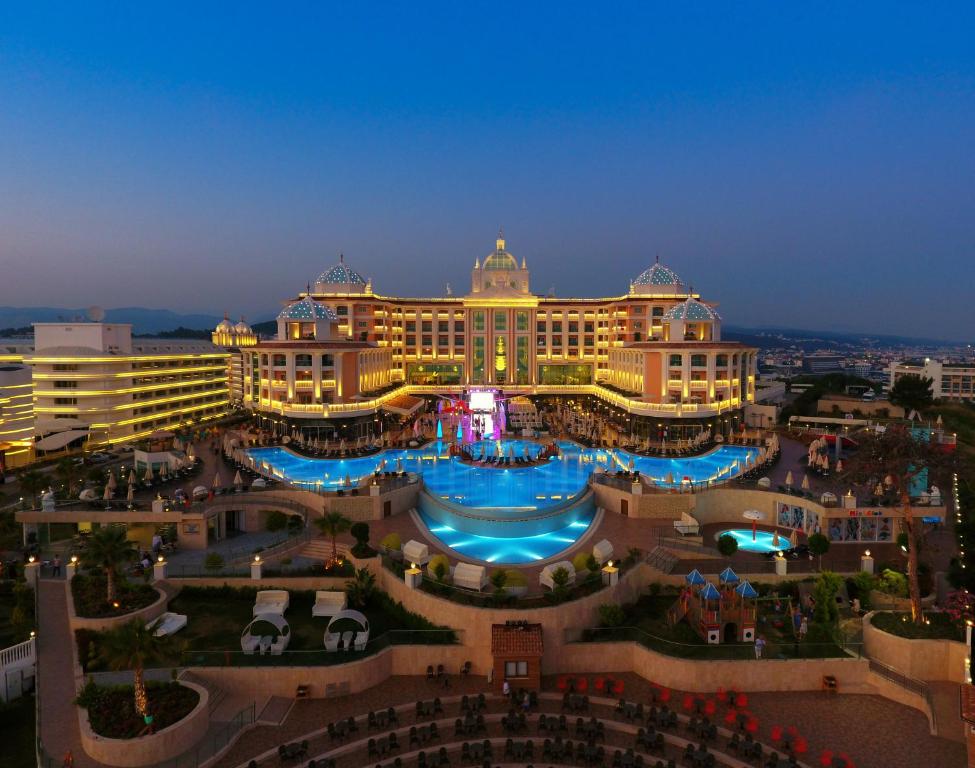 オクルカラールにあるLitore Resort Hotel & Spa - Ultra All Inclusiveの大きな建物の正面にプールがあります。