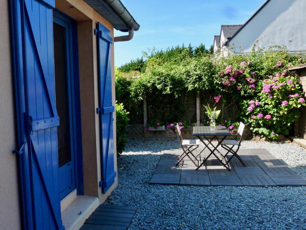 un patio con 2 sillas y una mesa fuera de una puerta en Suite à 800m de la plage, en Saint-Lunaire