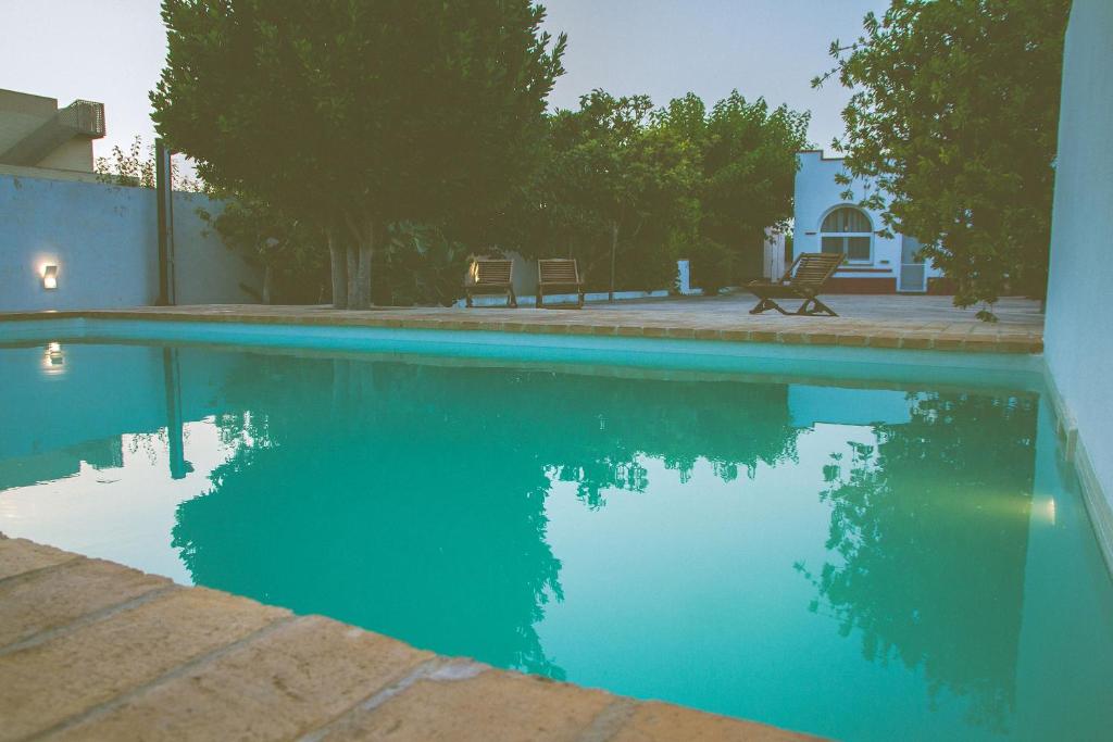 una piscina de agua azul con 2 sillas y una casa en Casa Bofranch, en Deltebre