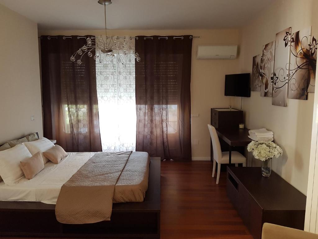 a bedroom with a bed and a desk and a window at Pompeii Ruins De Charme B&B in Pompei