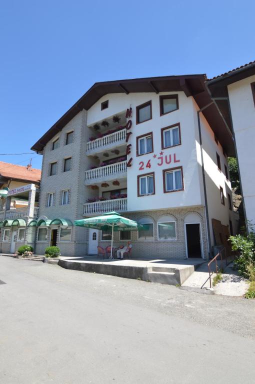 a large white building with an umbrella in front of it at Hotel 24 jul in Pljevlja