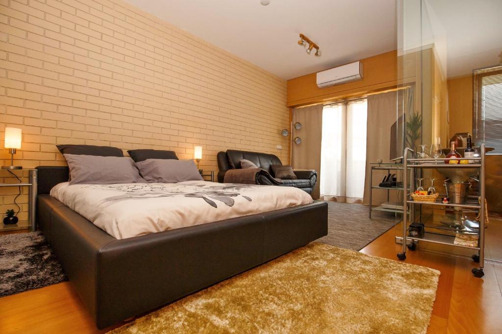 a bedroom with a bed and a couch and a chair at Studio Apartment Porto Gaia (Arrabida) in Vila Nova de Gaia