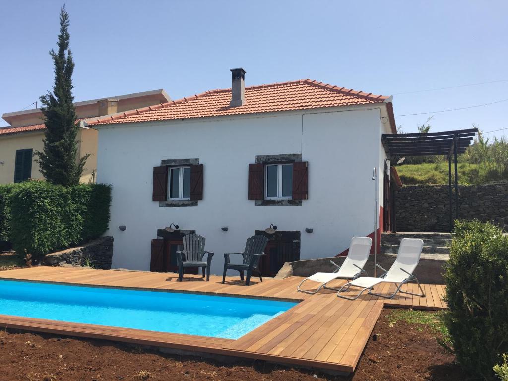 a house with a wooden deck and a swimming pool at Casa das Marias in Ponta do Pargo