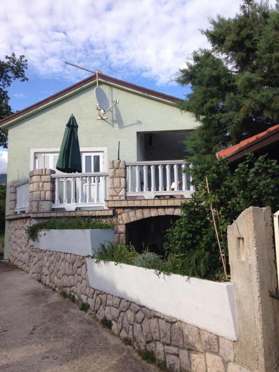 a house with a balcony and a stone wall at SanMari in Novi Vinodolski