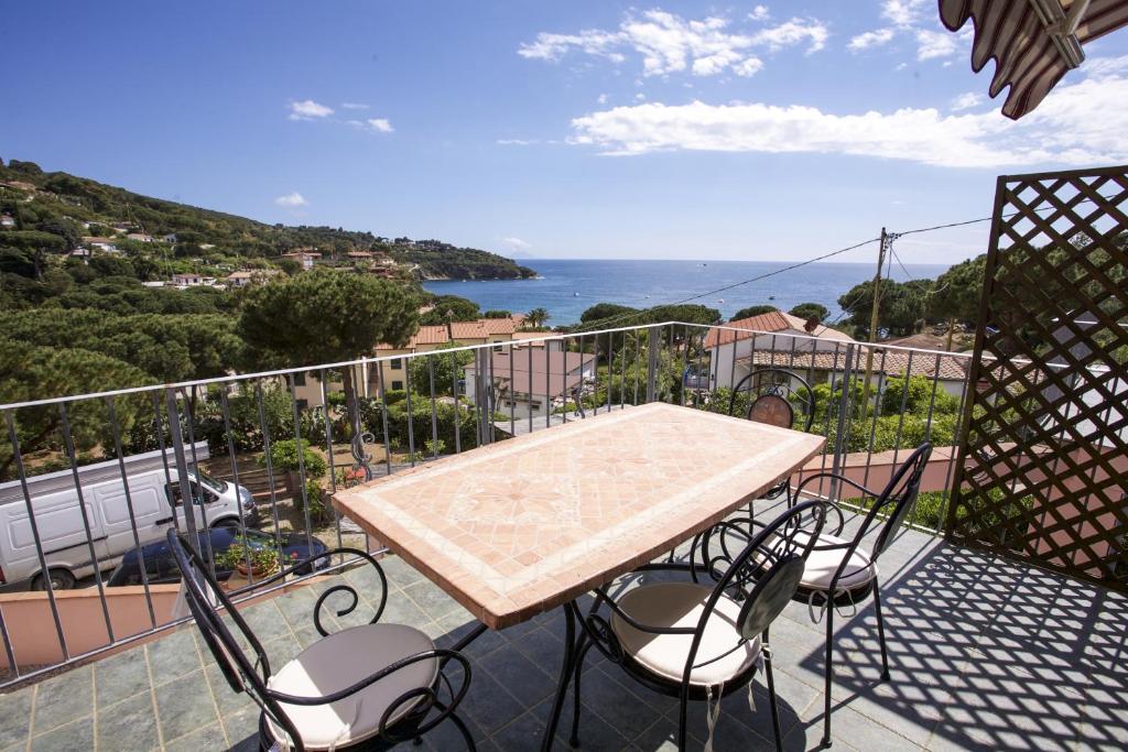 una mesa y sillas en un balcón con vistas al océano en Appartamenti Morcone - Goelba, en Capoliveri