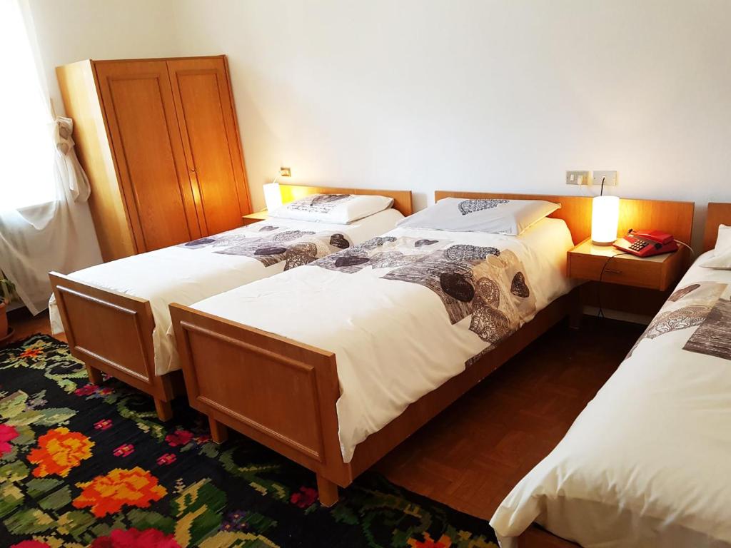 科萊聖盧恰的住宿－Albergo Posta，一间房间,有三张床