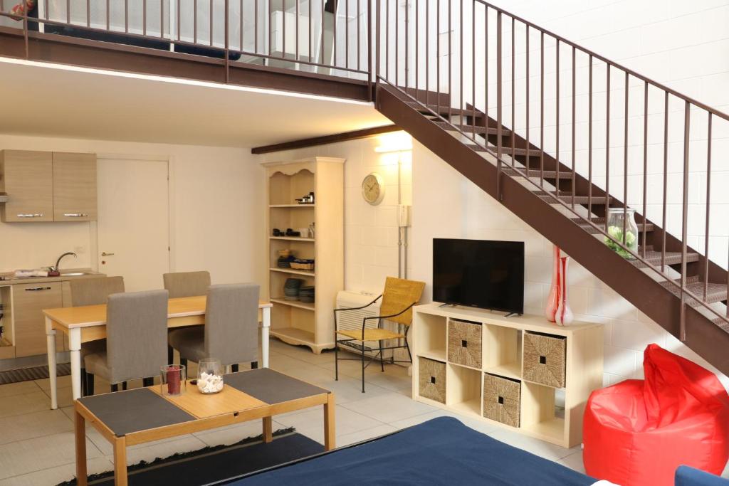 a living room with a kitchen and a staircase at LoftinComo in Como