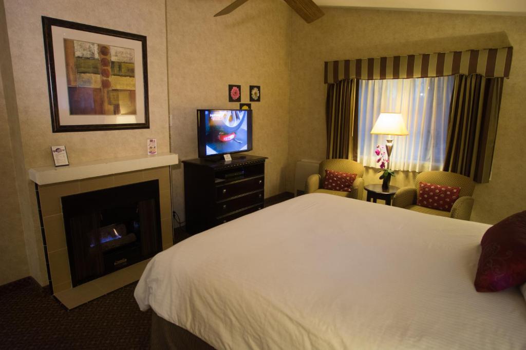 ein Hotelzimmer mit einem Bett und einem TV in der Unterkunft Rosedale Inn in Pacific Grove